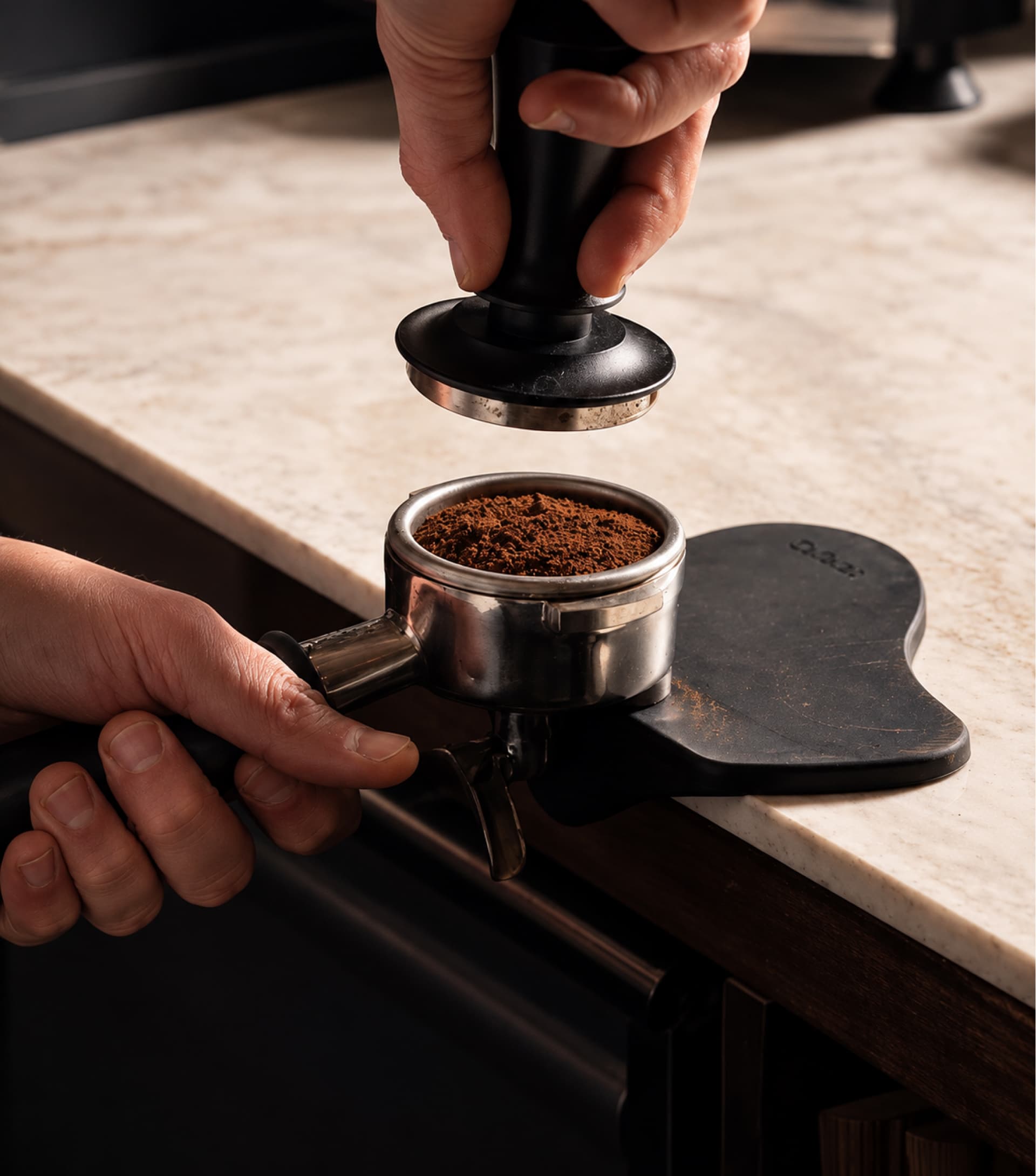 Ground coffee being tamped into a portafilter